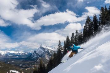 Skier at a steep angle skiing in fresh powder at Mount Norquay in Banff National Park