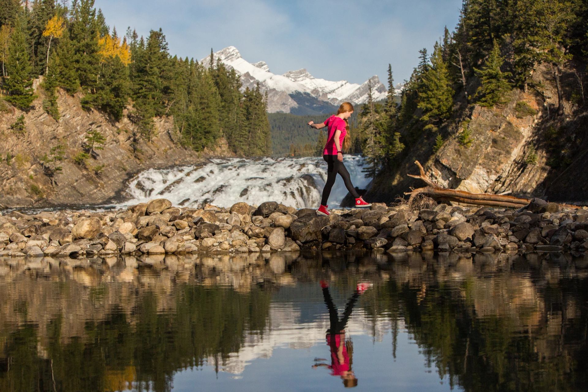 A girl walking by Bow Falls beside the Bow River in Banff