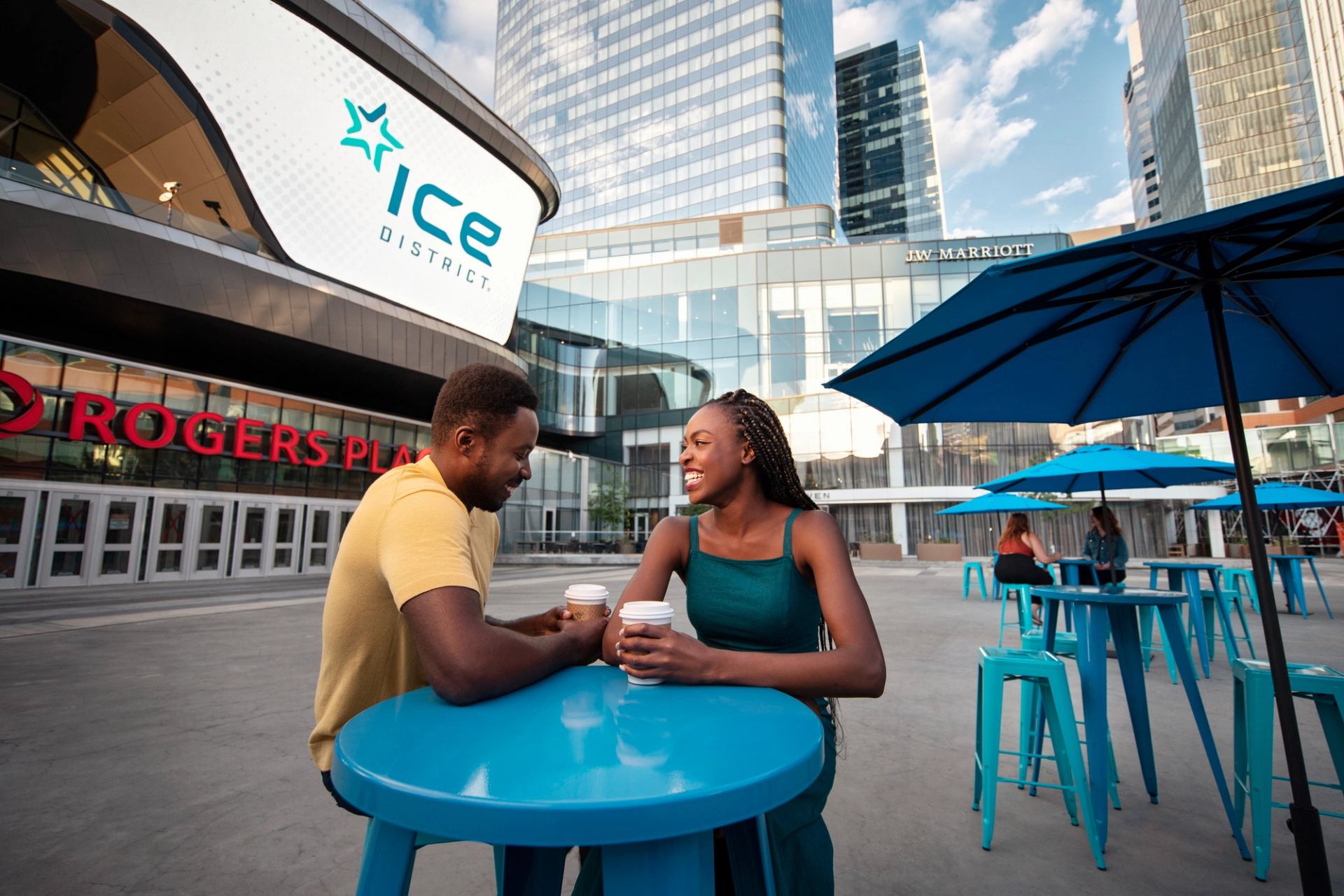 A young couple drinking coffee in the ICE District, in Edmonton