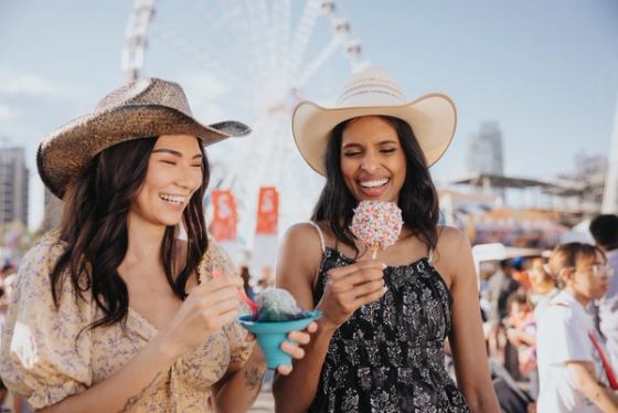 Women enjoying some midway food and treats at the Calgary Stampede.
