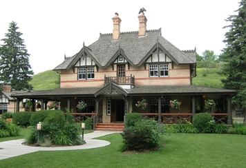 Exterior of historical building turned into a restaurant with a lush garden out front.