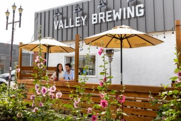 Two people sitting on a patio at Valley Brewing in Drumheller.