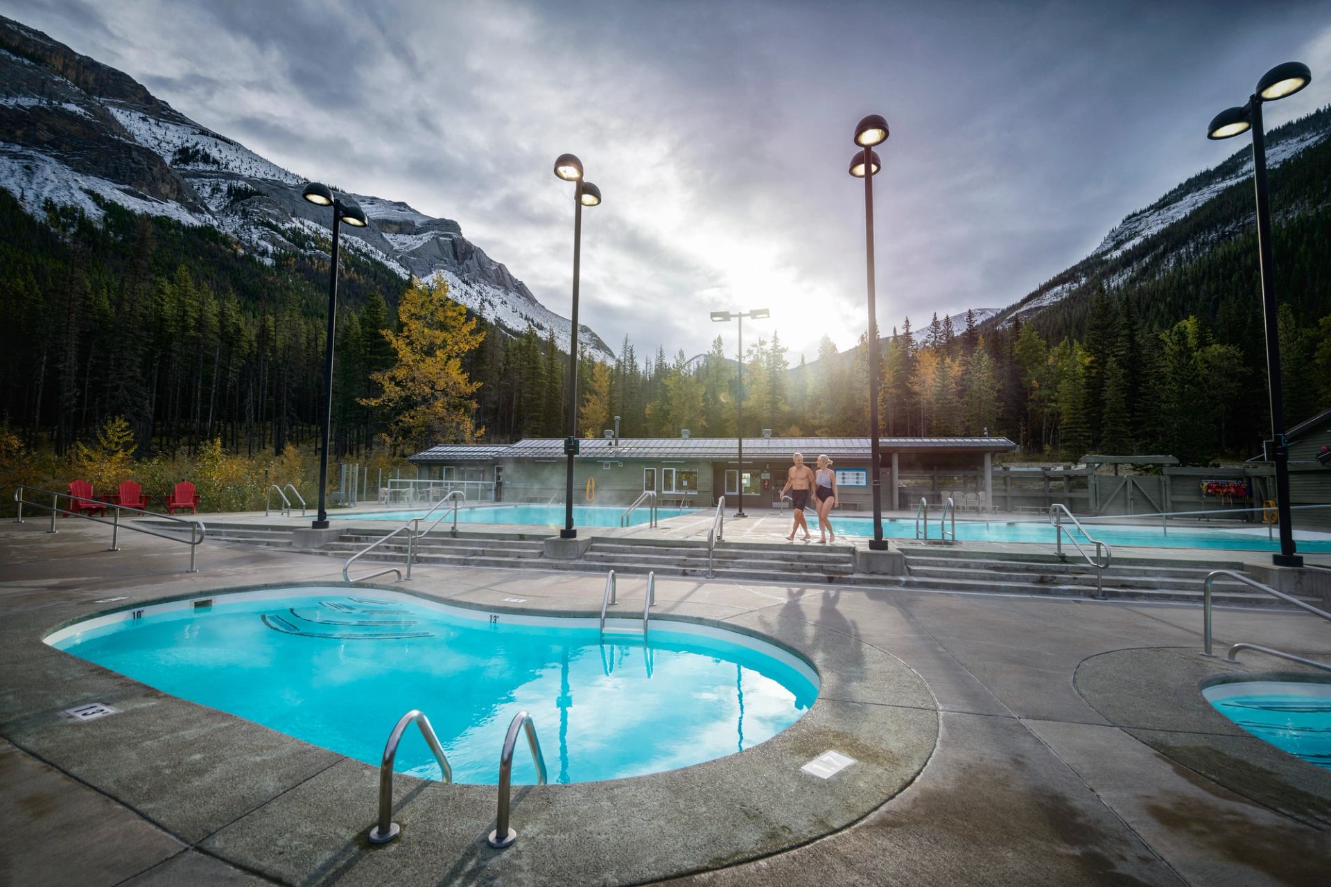 Two people walking between pools at the Miette Hot Springs.