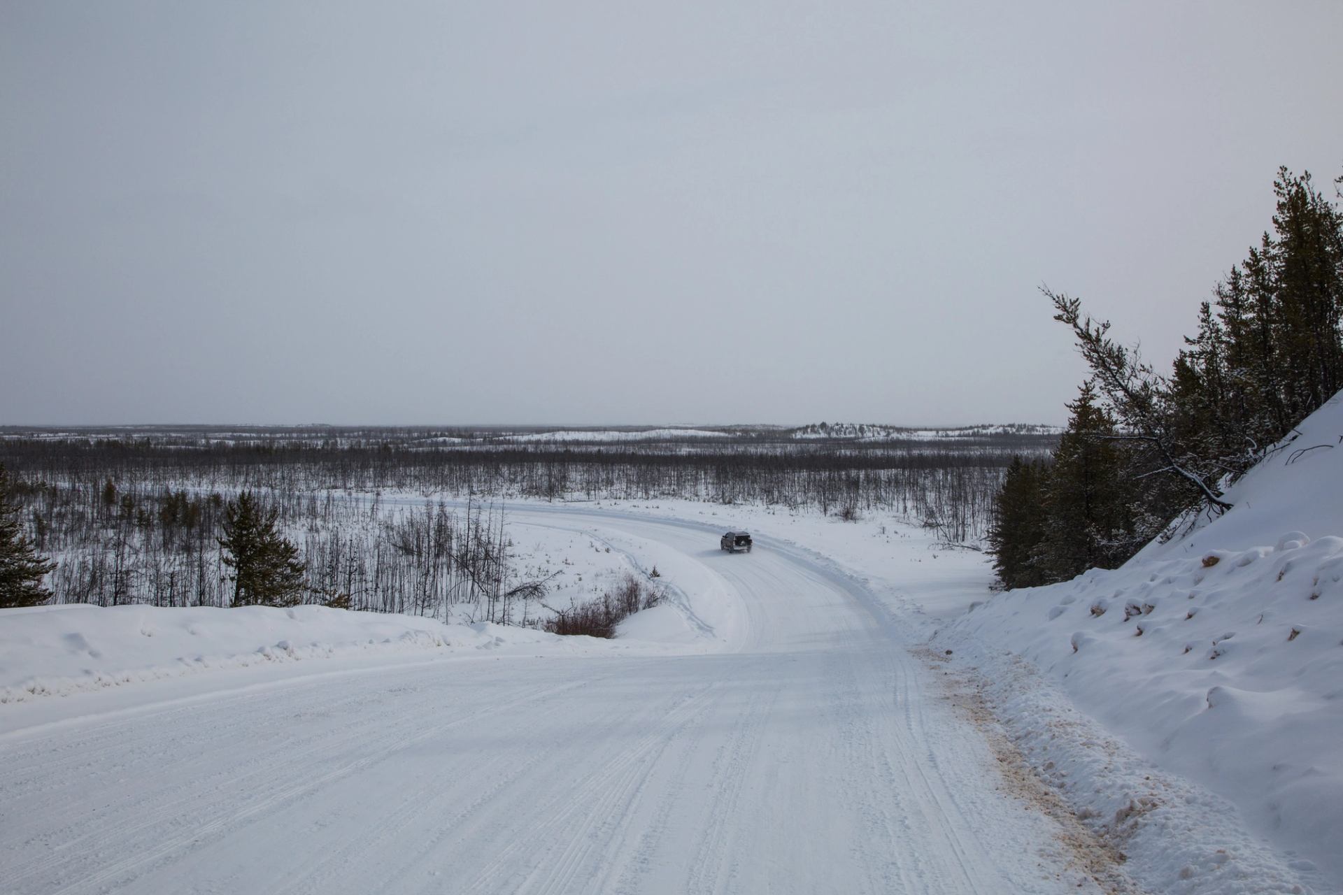 A car drives down a winter road to Fort Chipewyan from Fort McMurray.