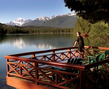 A man looking at Hector Lake at the Fairmont Jasper Park Lodge in Alberta