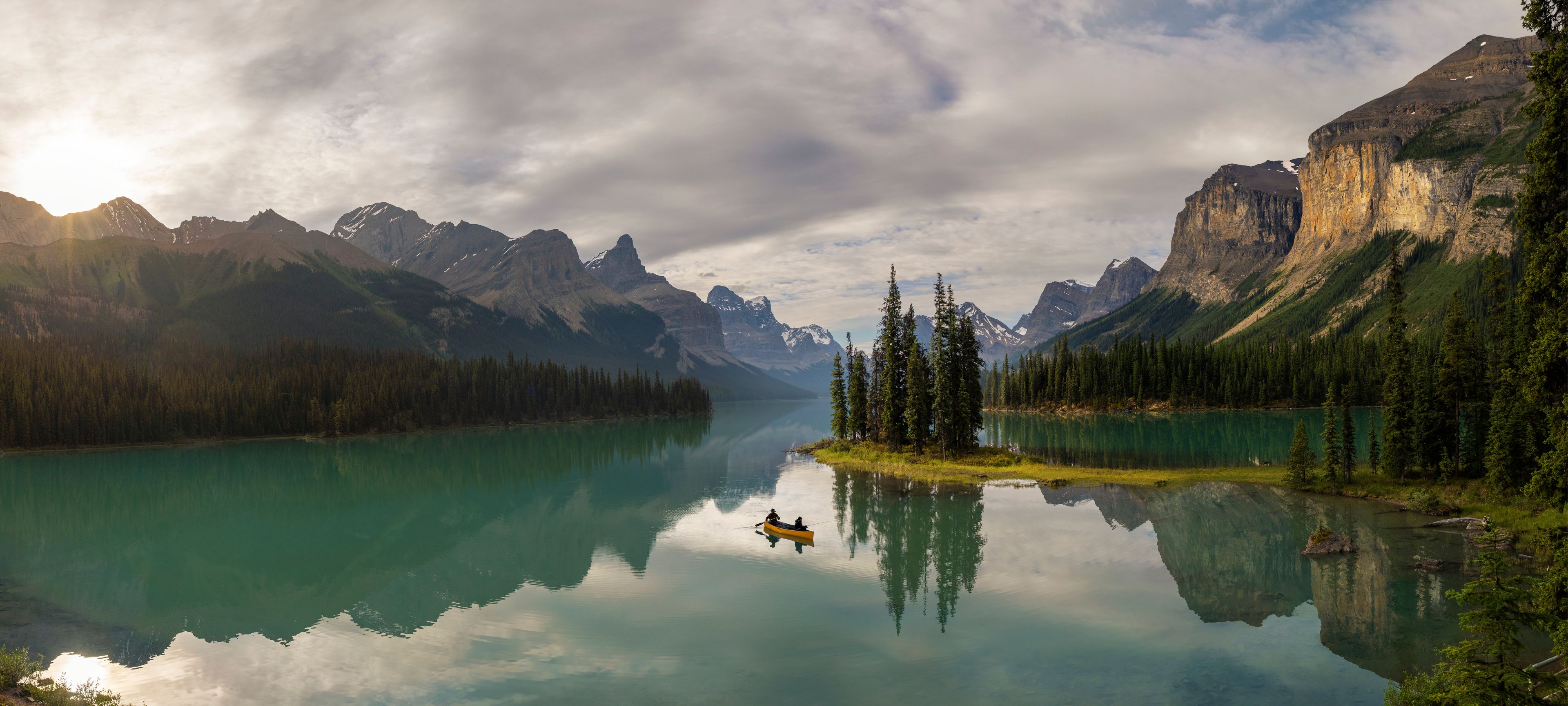 A yellow canoe in front of Spirit Island in early dawn light at Maligne Lake in Jasper National Park.