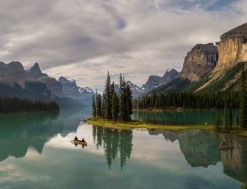 A yellow canoe in front of Spirit Island in early dawn light at Maligne Lake in Jasper National Park.