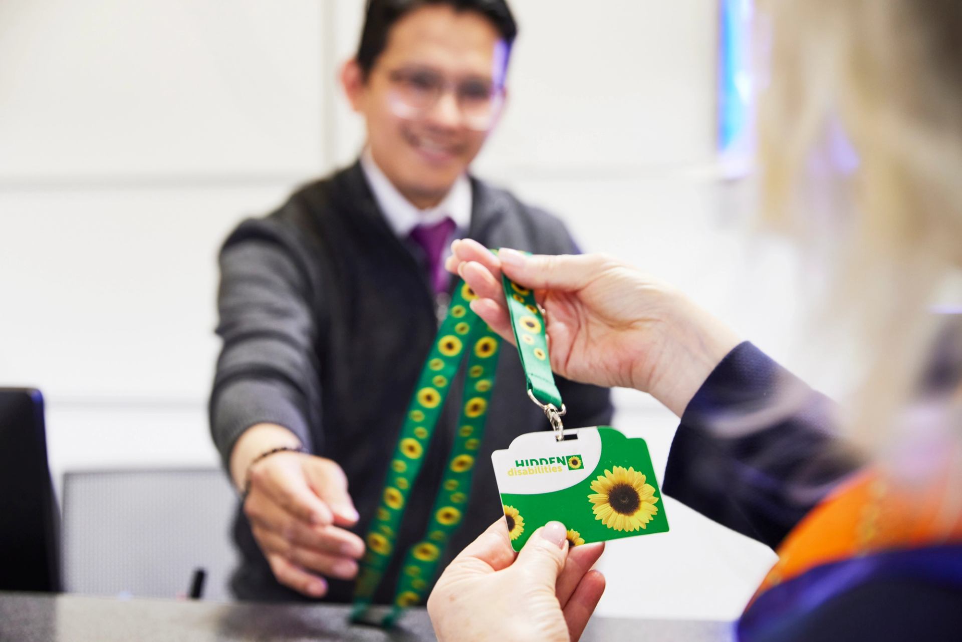A badge and lanyard showing the logo for the Sunflower Program for accessibility.