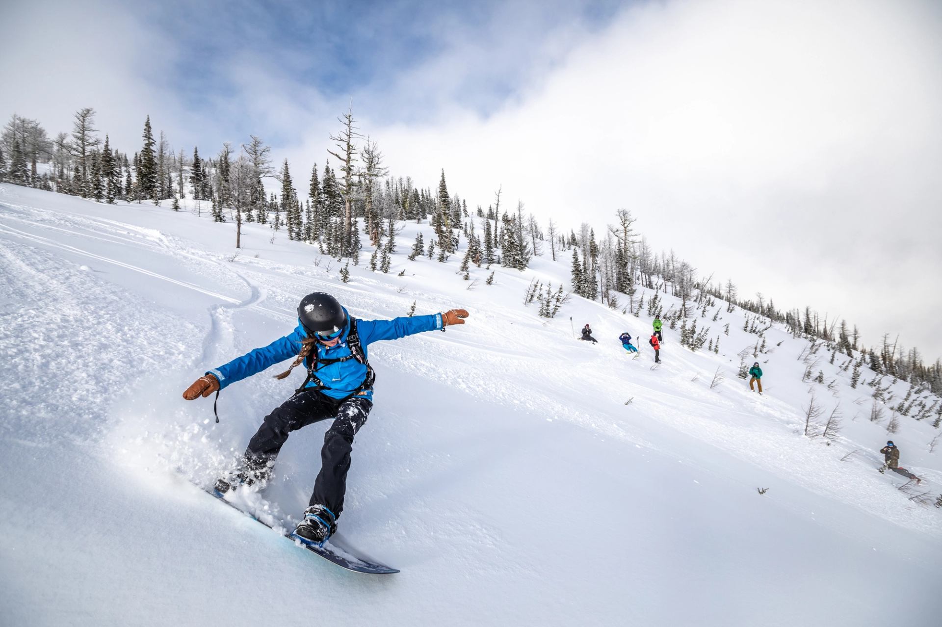 A snowboarder carves down the side of Castle Mountain.