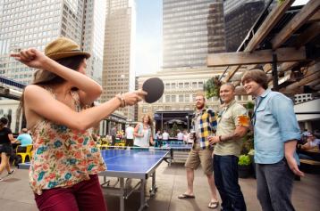 Friends playing ping pong on the patio at The National on 8th Avenue in Calgary.