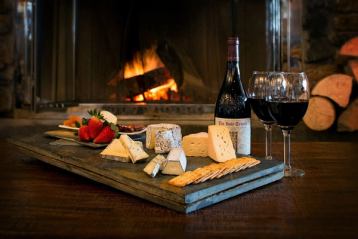 Close-up of wine and cheese by the fireplace inside Chimney Corner at Sunshine Village in Banff National Park