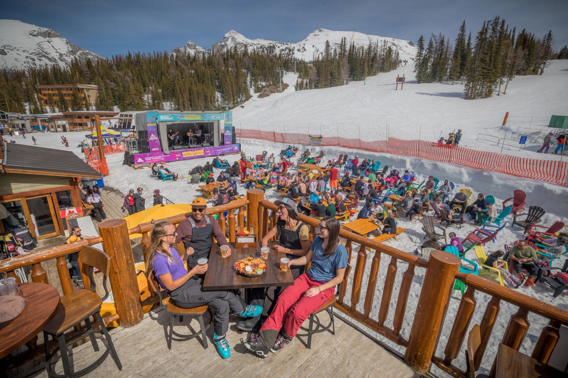 Friends enjoy a patio, listening to live music after a day of spring skiing at Banff Sunshine Village.