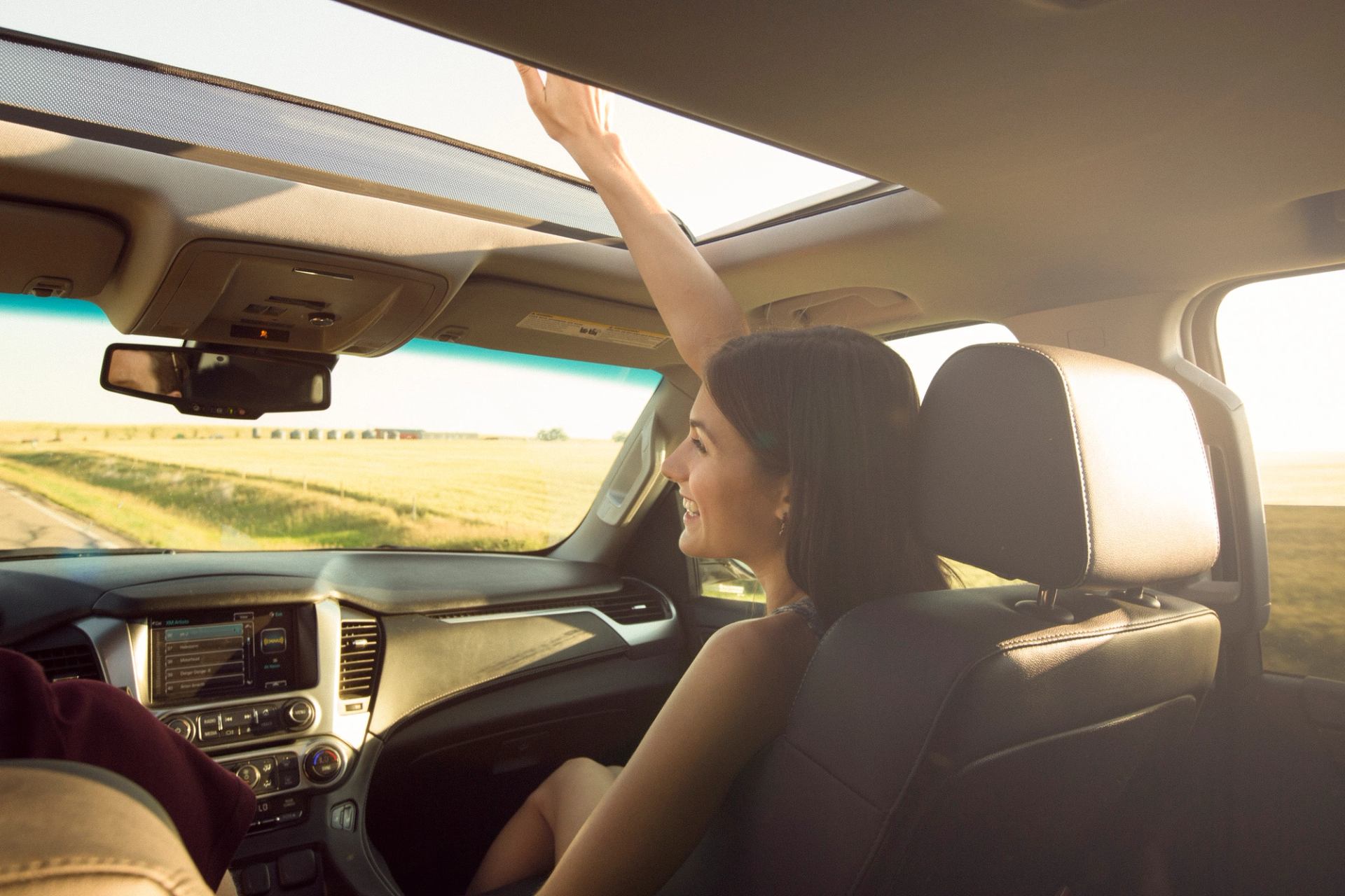 A young woman in a car on a road trip