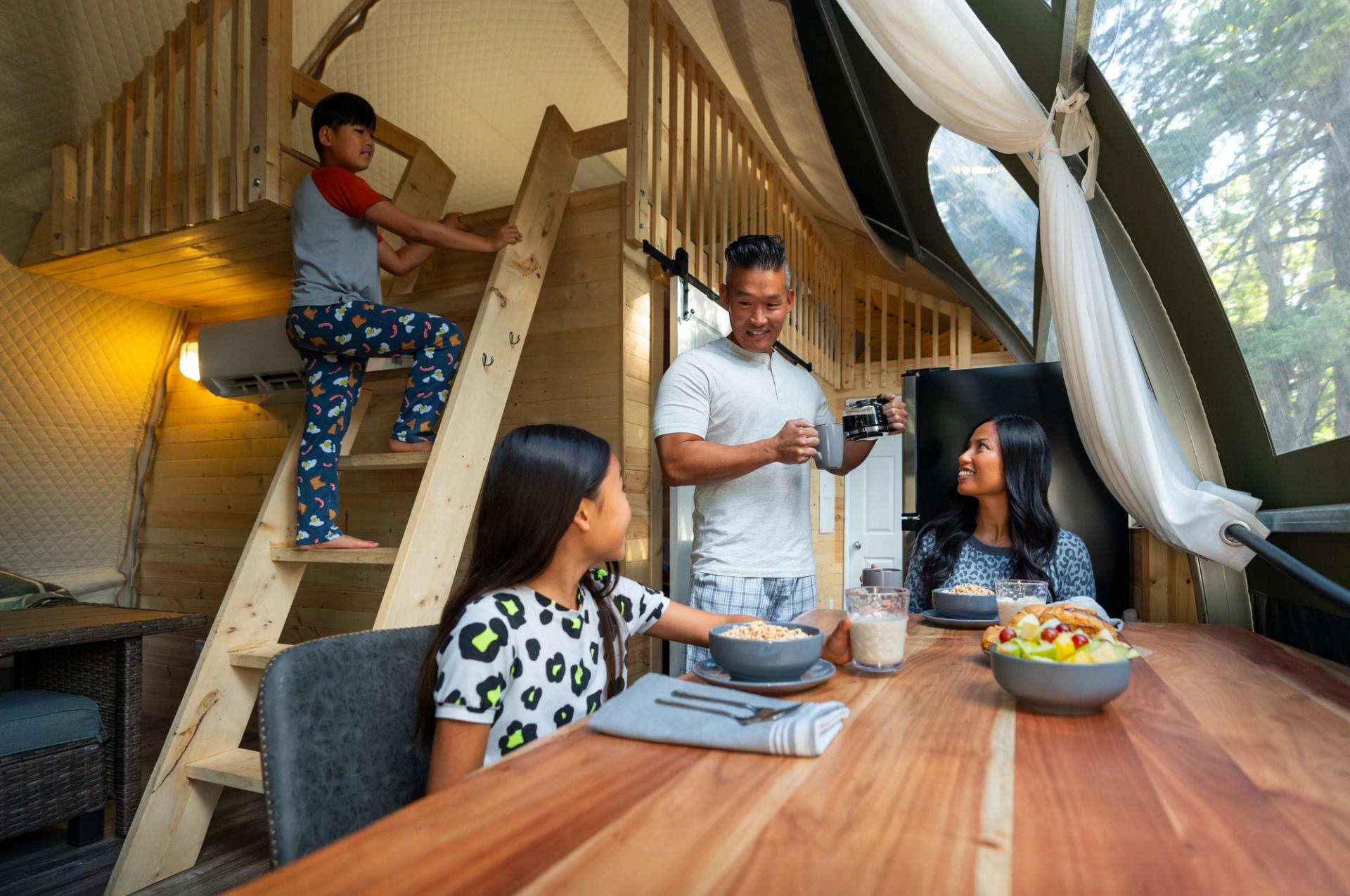 A family enjoys breakfast together inside one of the lodges at Glamping Resorts in Castle Provincial Park.