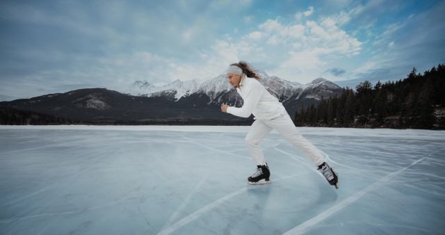 A man ice skating in the Rocky Mountains.