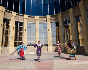 Siksika Blackfoot dancers in front of the Blackfoot Crossing Historical Park Interpretive Centre.