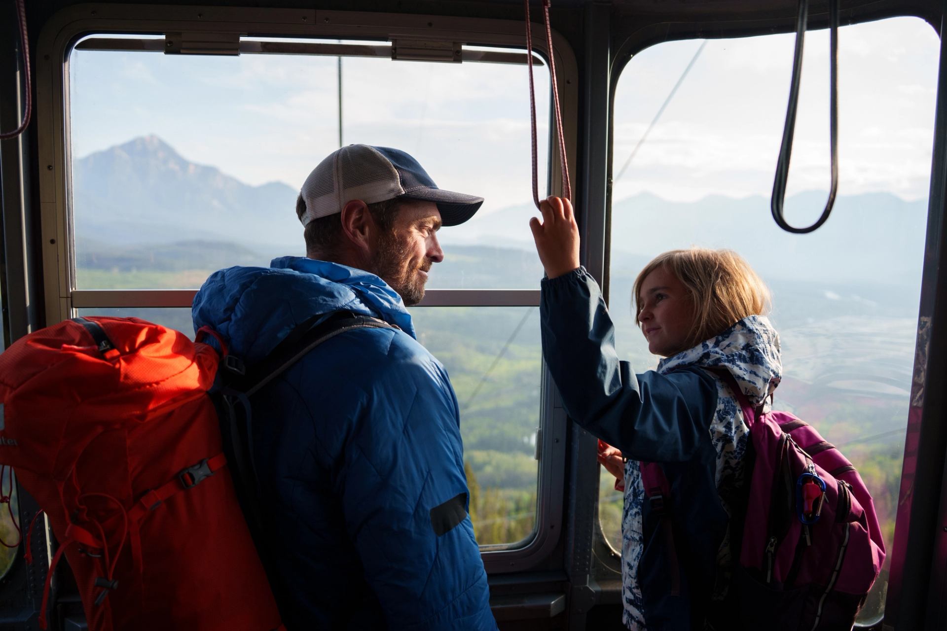 A man and his daughter riding the SkyTram.