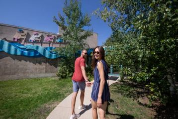 Man and women holding hands and smiling as they walk up to an Interpretive Centre.