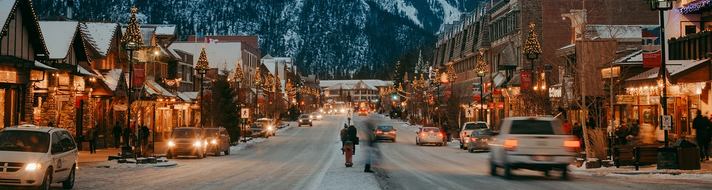 Banff Ave in winter, in the evening, mountains in the background in Banff National Park.