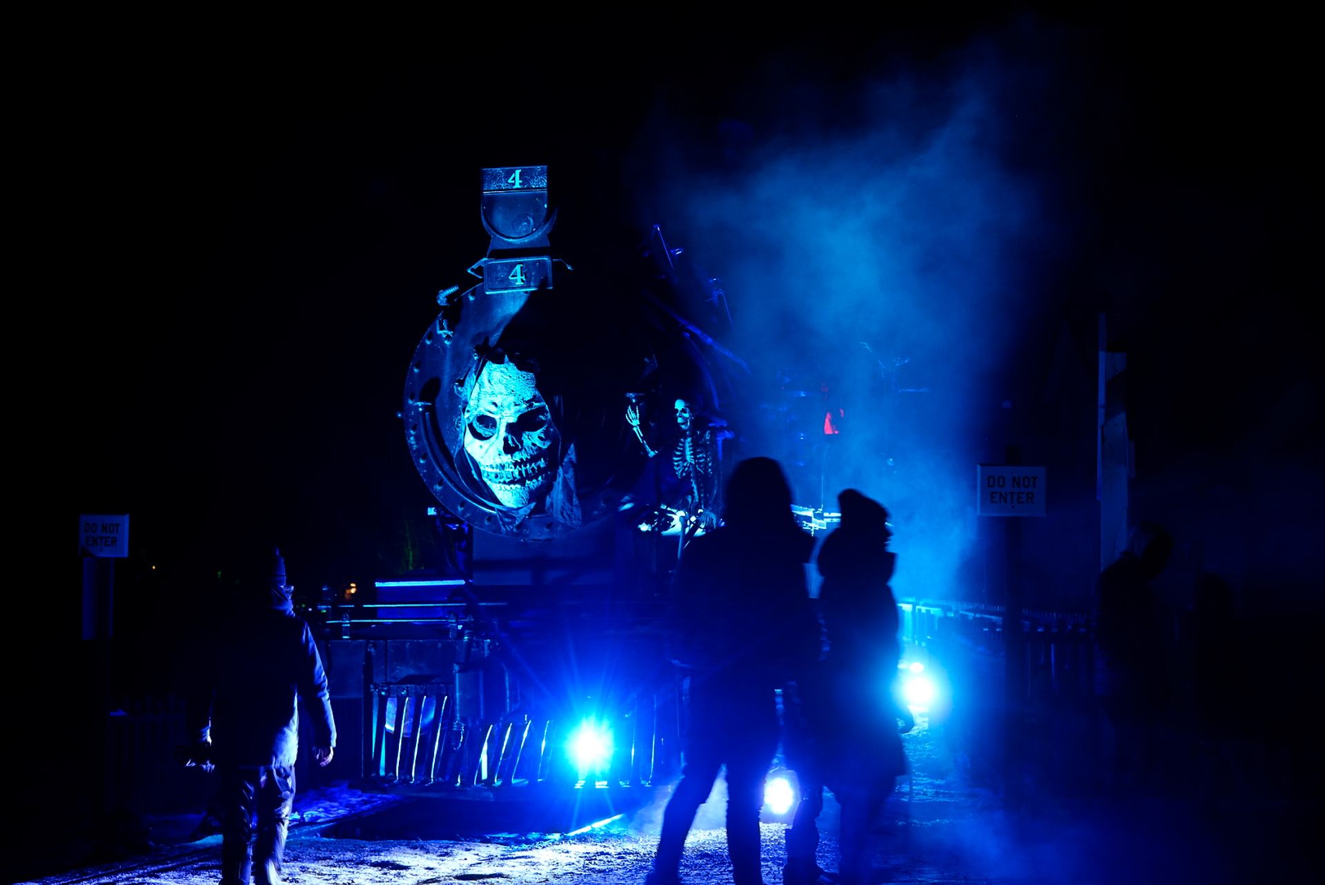 People stand in front of a Halloween-themed ghost train at Heritage Park.