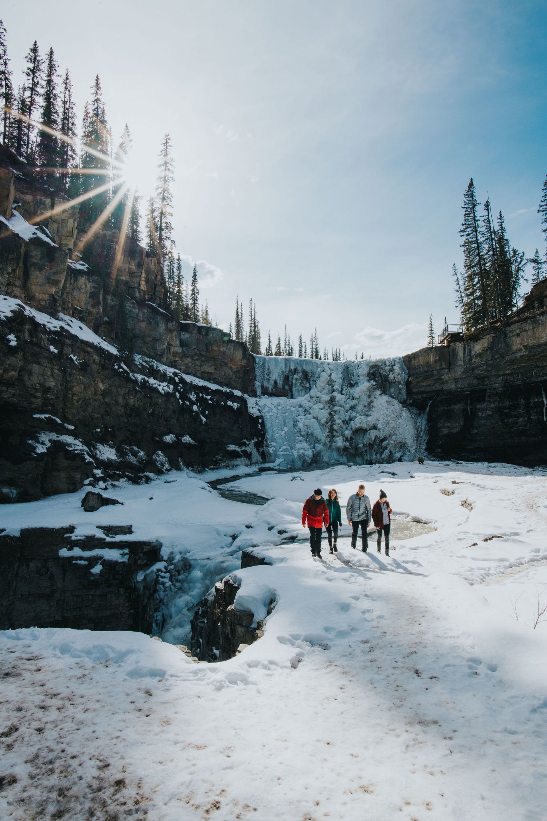 A family enjoys the frozen waterfall at Crescent Falls in Clearwater County, Nordegg