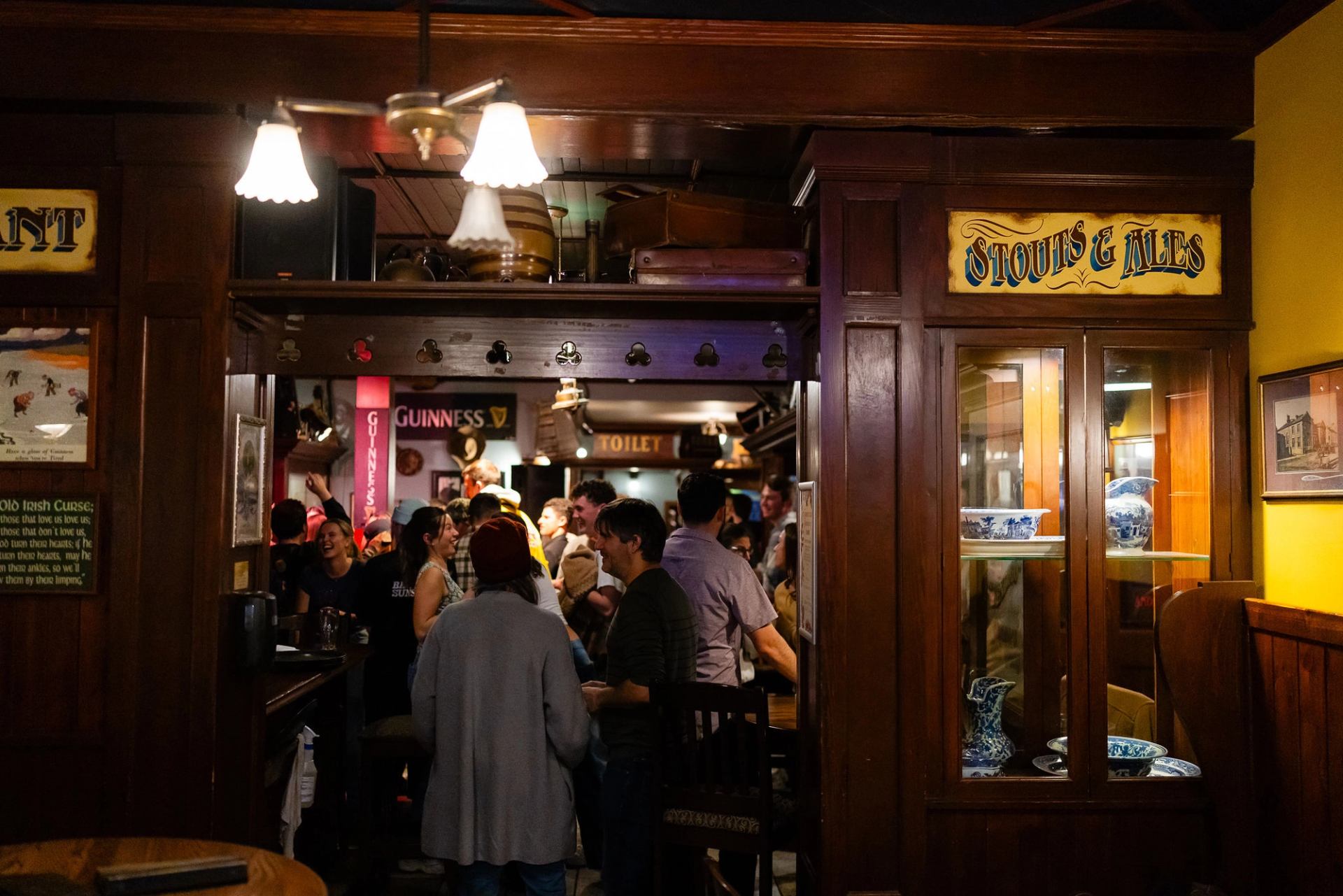 Diners crowd into an Irish-style pub in Banff, with warm wood and vintage-inspired signage.