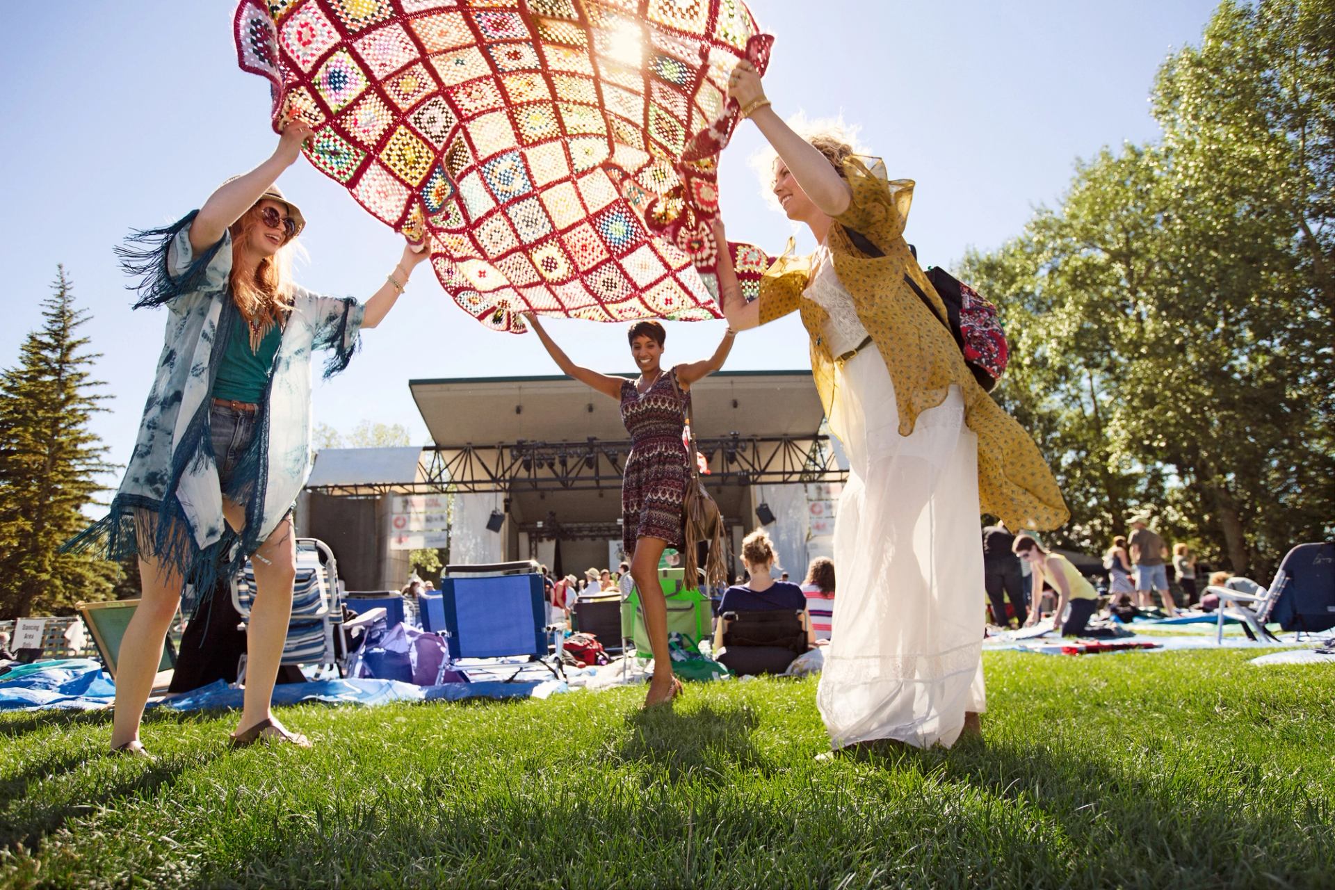 Friends placing a blanket down at the Calgary Folk Festival