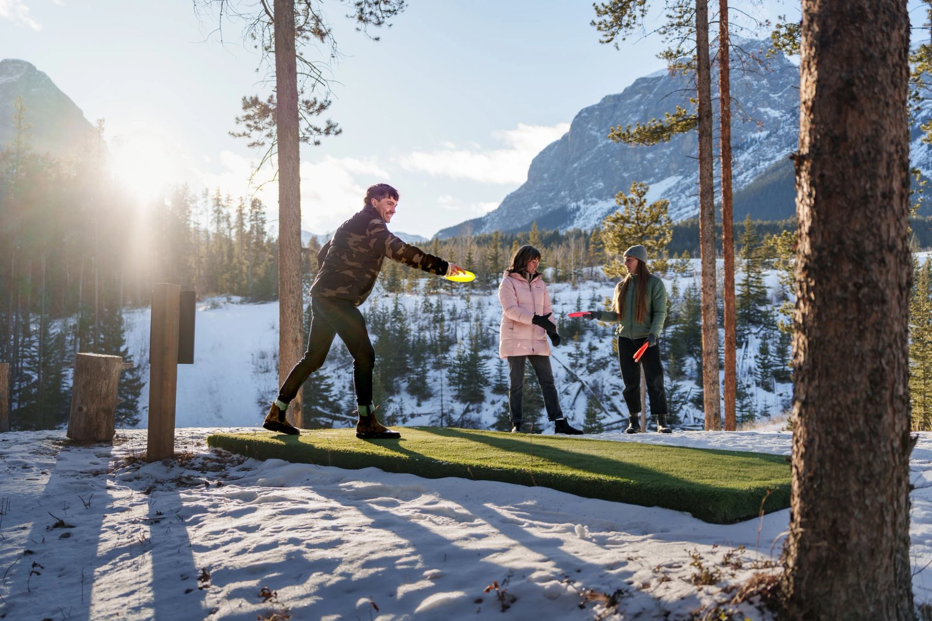 A group of friends playing winter disc golf at the Canmore Nordic Centre.