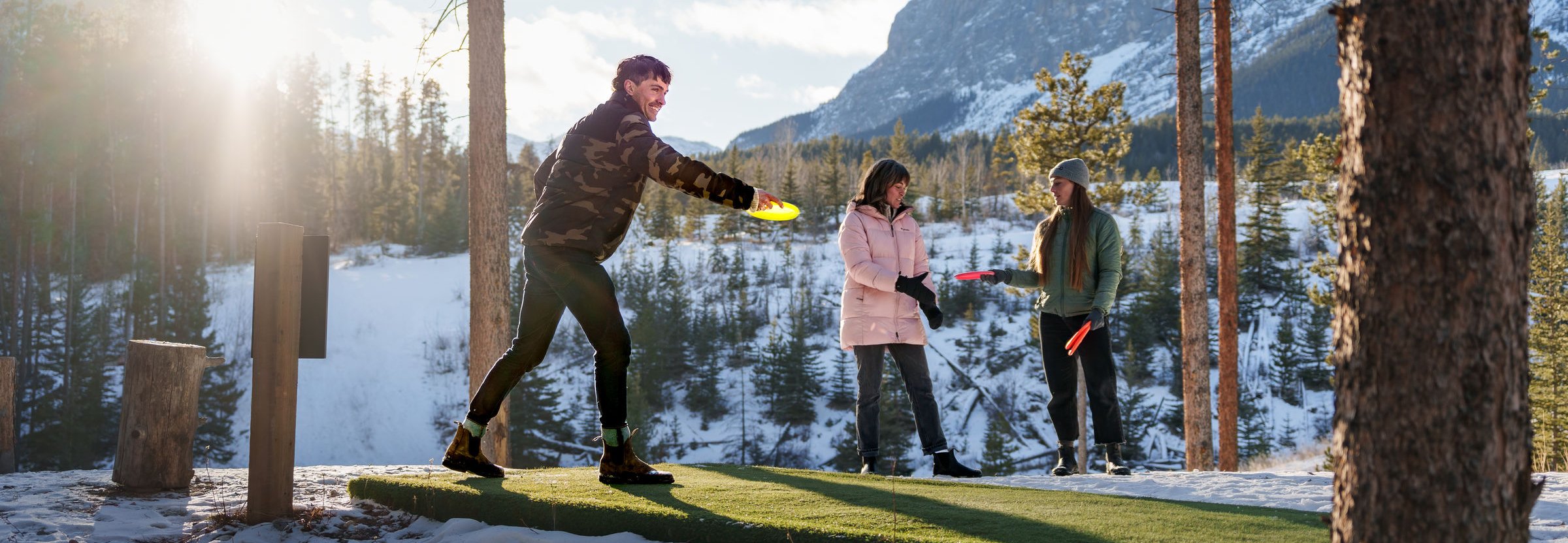 Friends play disc golf outdoors in winter