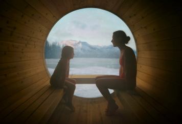 A mother and daughter in a barrel sauna.