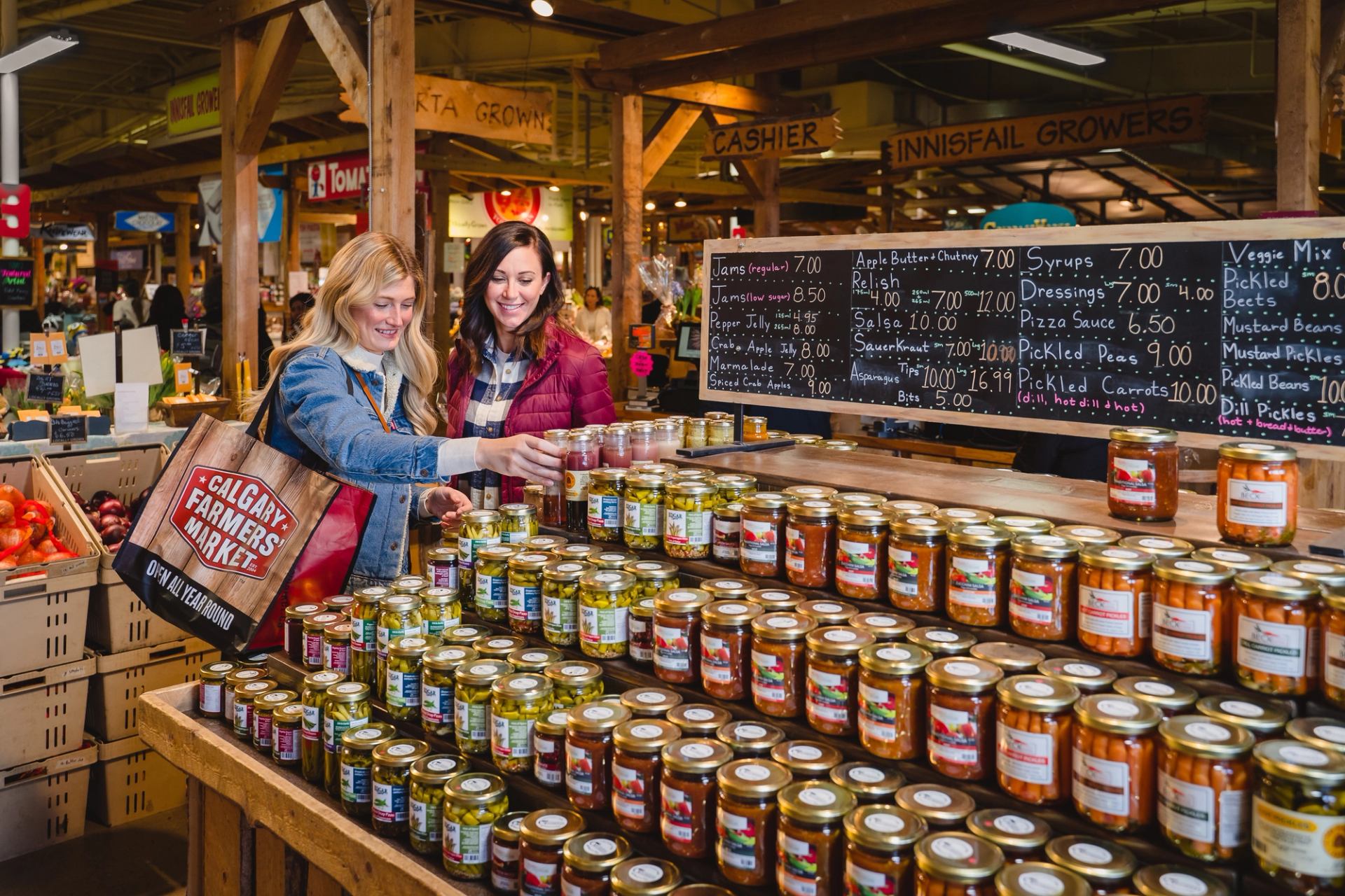 Two women shopping for preserves at the Calgary Farmers’ Market.