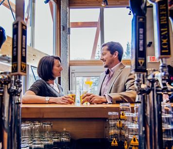 A couple having a beer at the bar of a brewery.