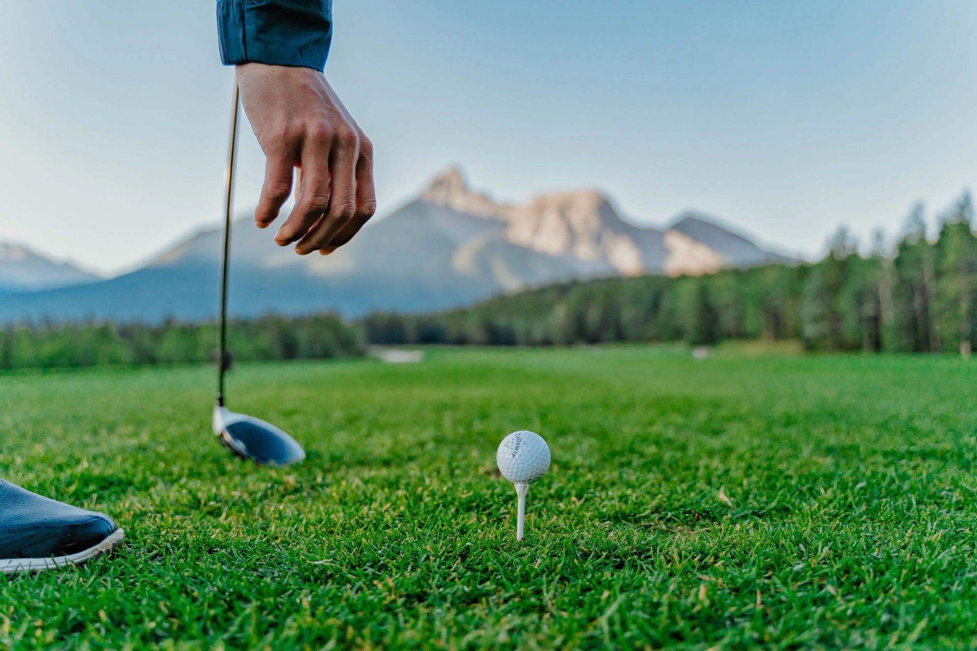 Hand reaching down to ball on golf course