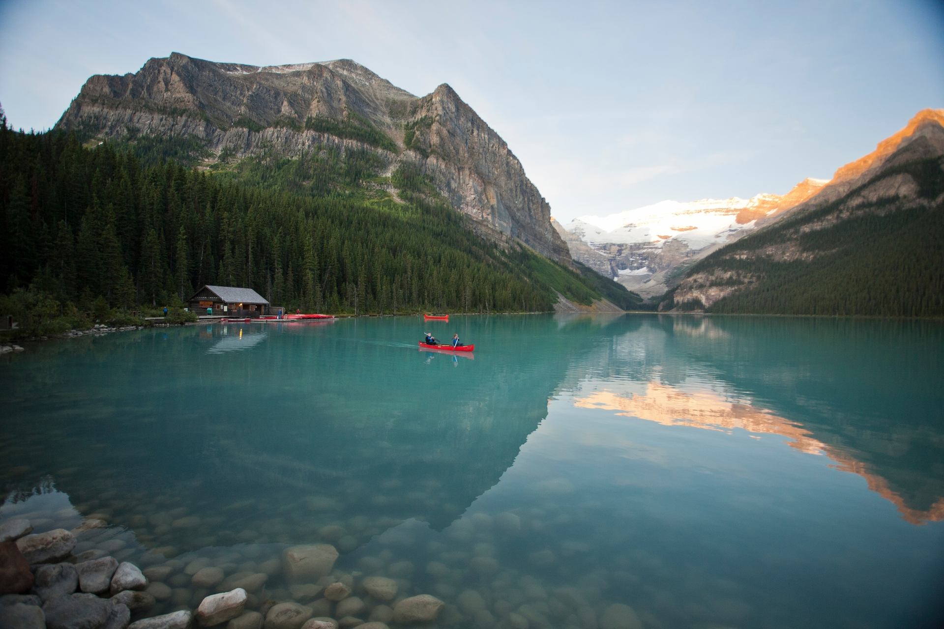 A couple paddles a canoe across Lake Louise in Banff National Park.