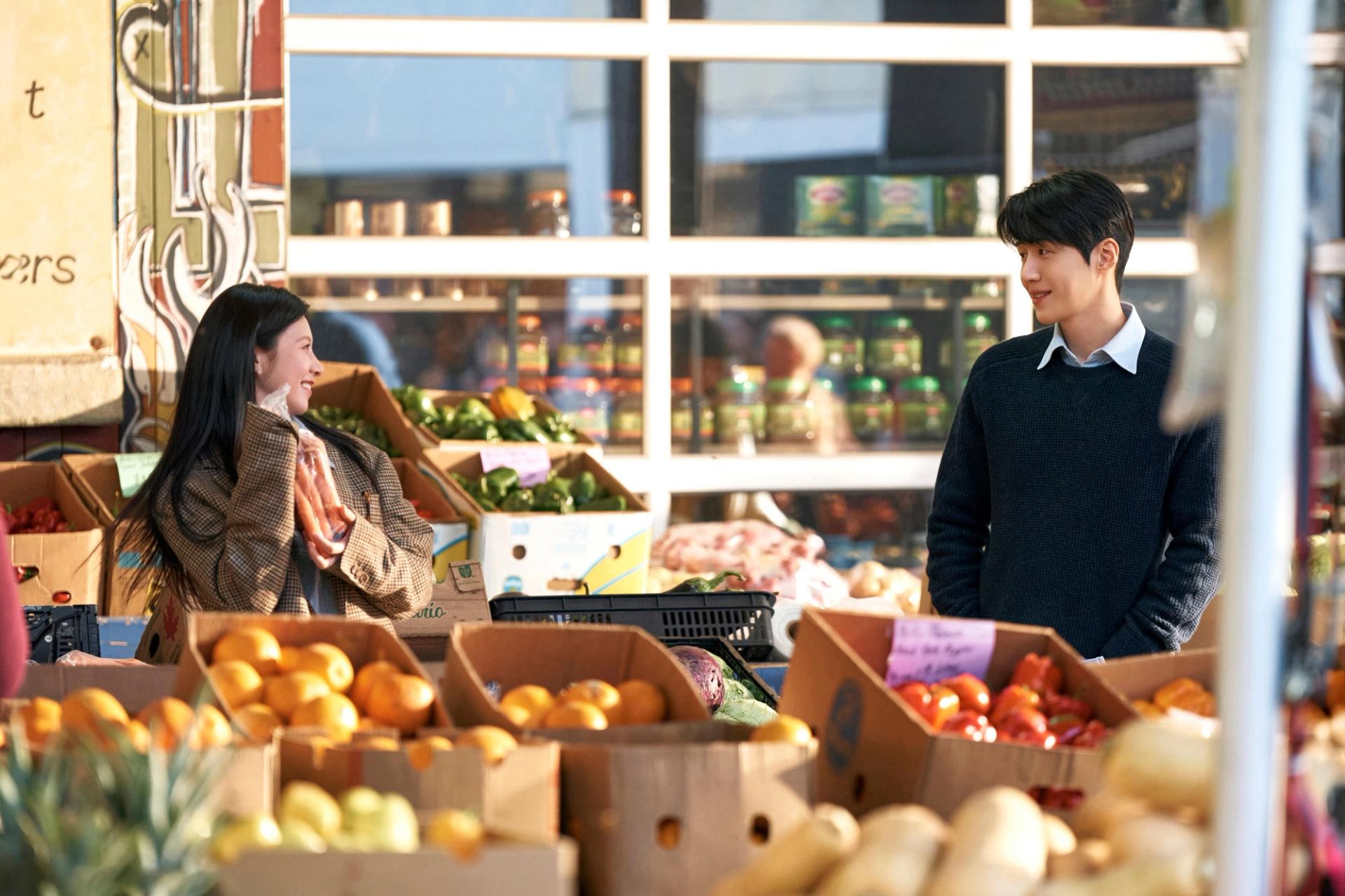 Two characters shop for produce at Crossroads Market in a still image from "Can This Love Be Translated?"
