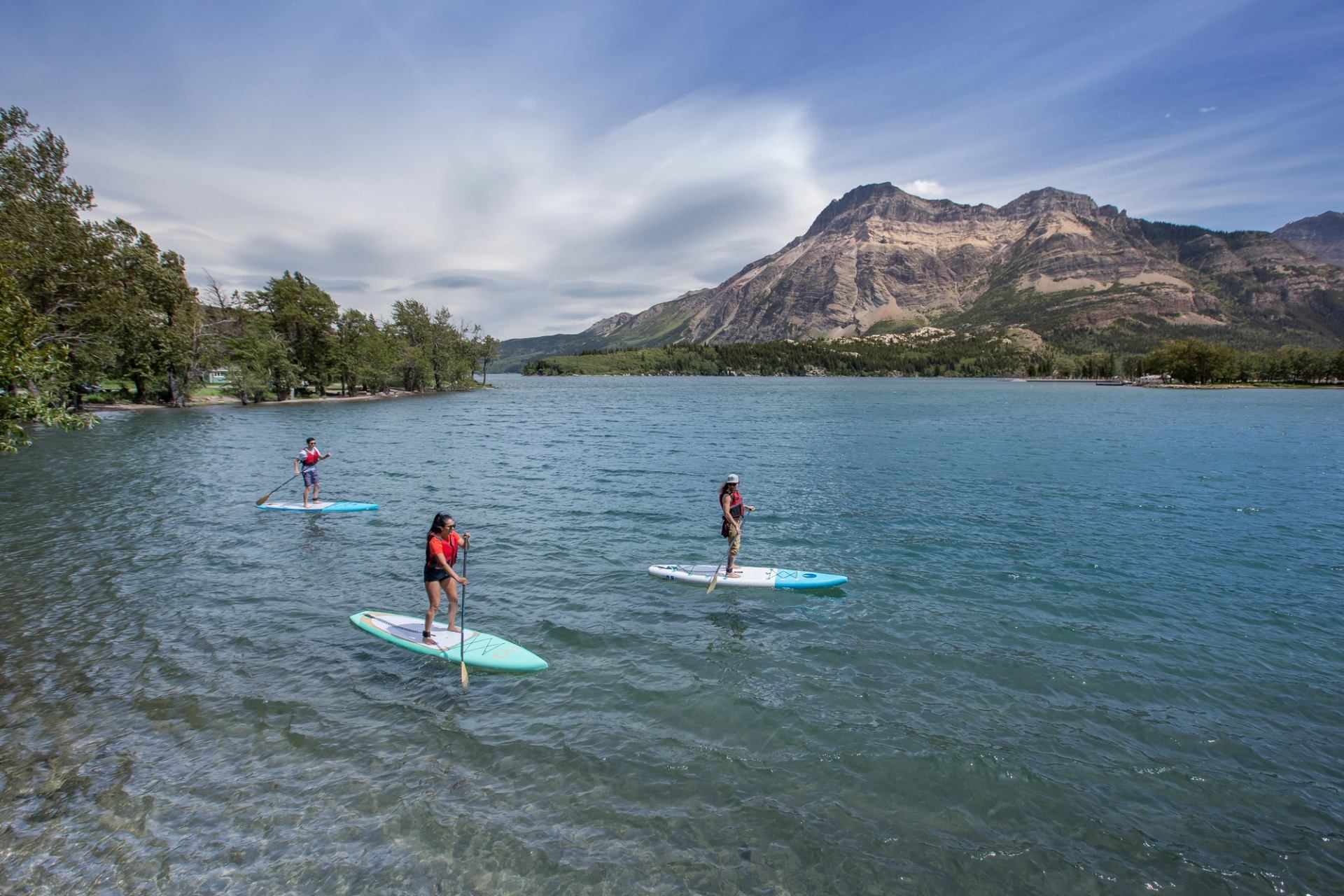 A group out paddleboarding on a lake in Waterton.