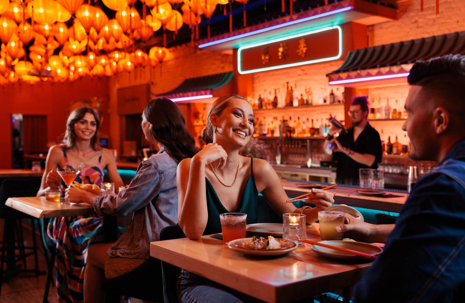 People dine at Fu's Repair Shop, with red lanterns hung artfully across the ceiling.