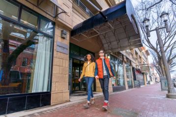 Couple walking outside of the Metterra Hotel in downtown Edmonton