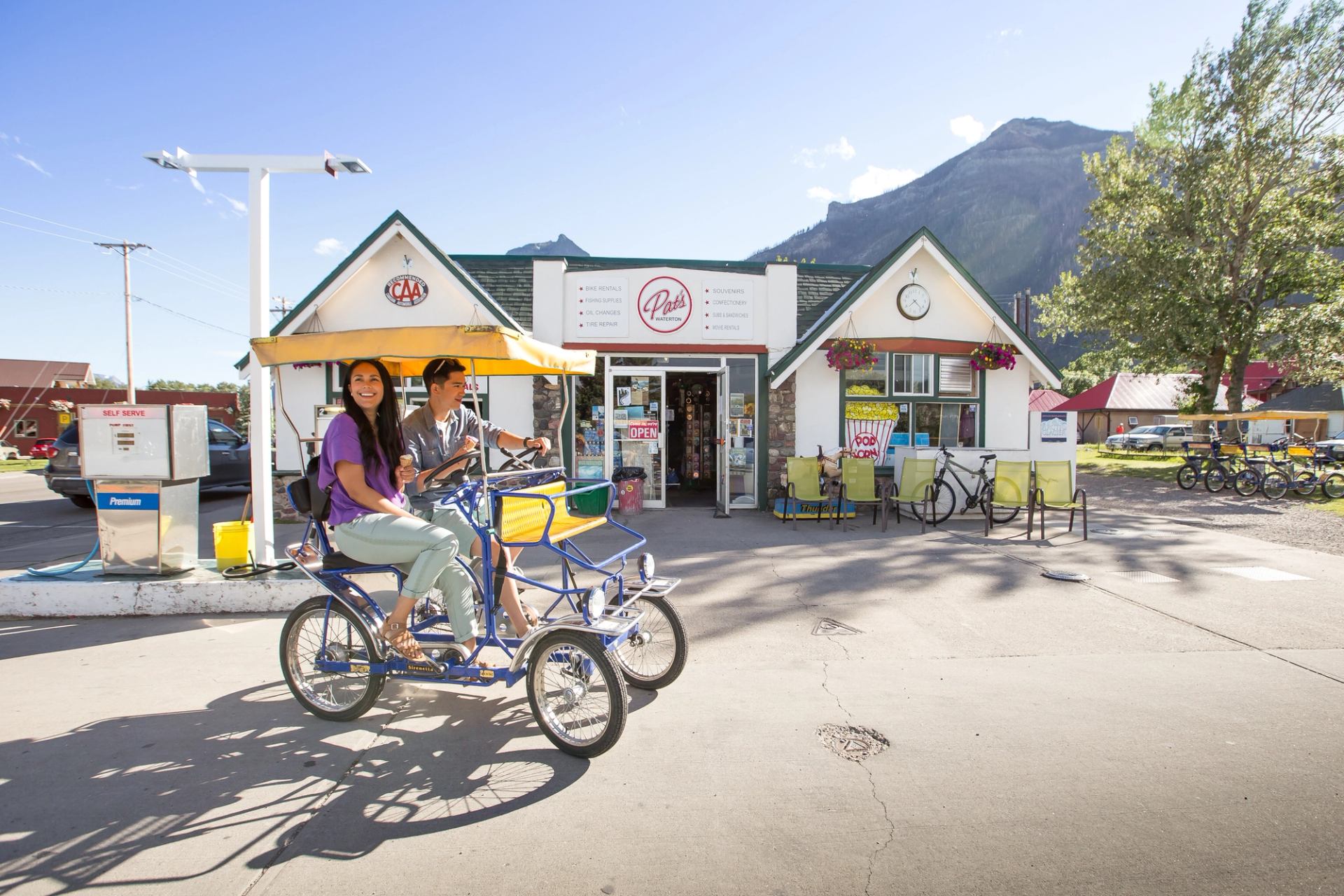 Travellers pedal a four-wheel bicycle in the town of Waterton.