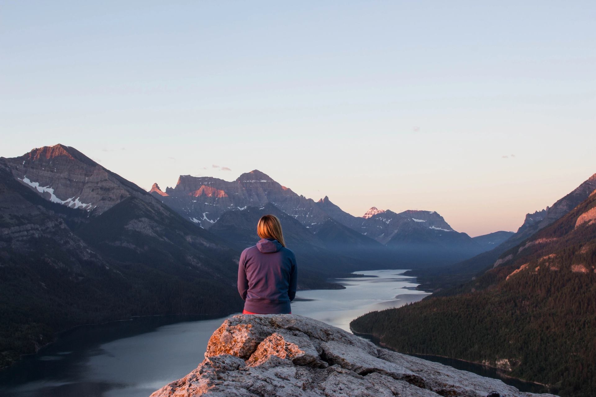 A women sits on a rock looking out over Waterton Lakes