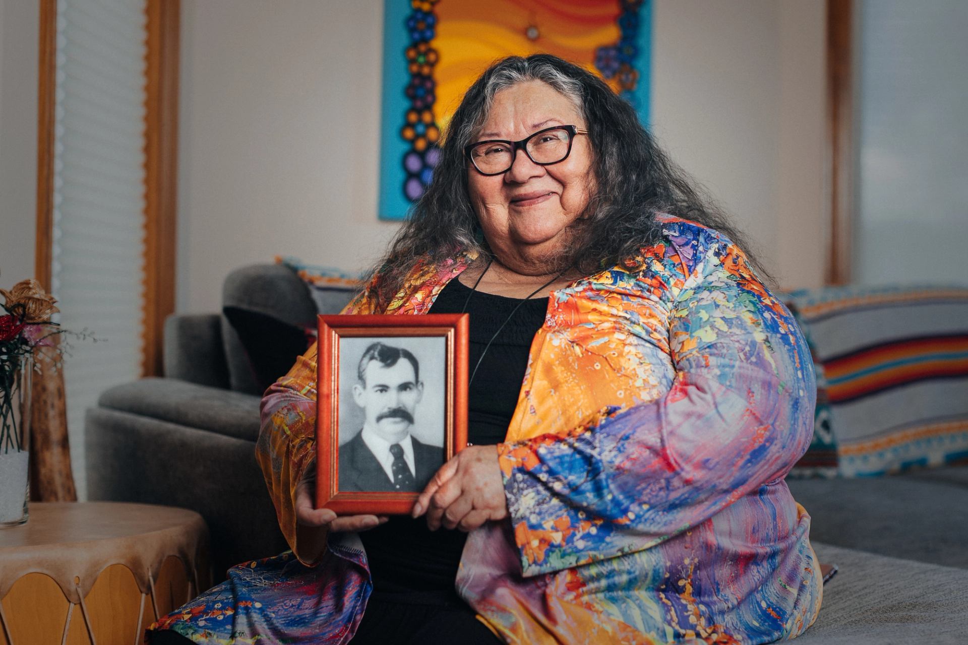 Yvonne Jobin, founder of Moonstone Creation, holds up a framed portrait.