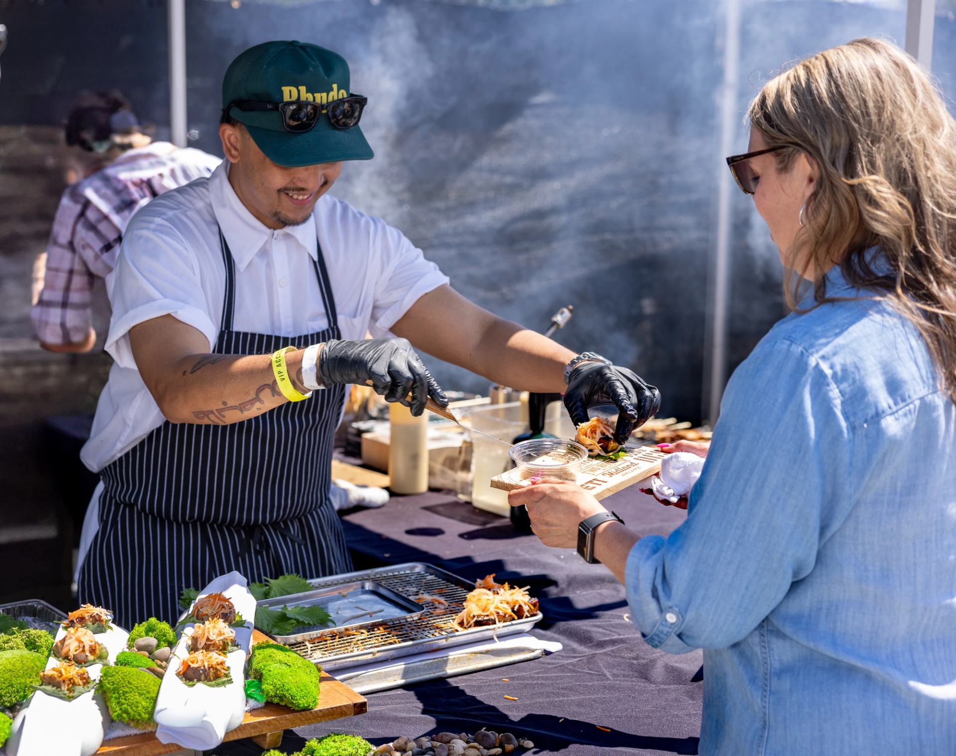 A chef serving a guest fresh food from the grill at Brewery & the Beast, in Calgary.