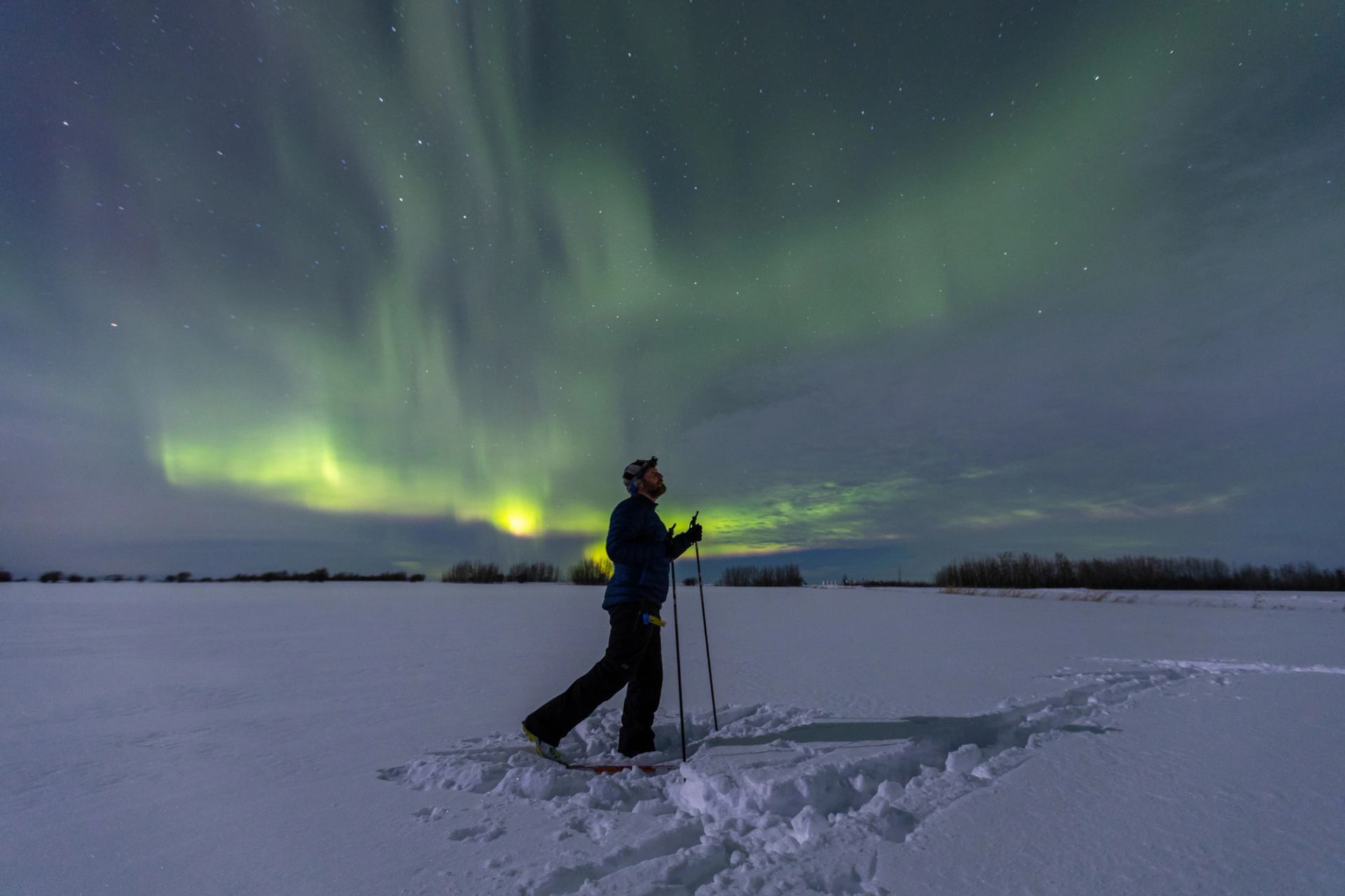 Man cross country skiing looking at the Northern lights in Peace River.