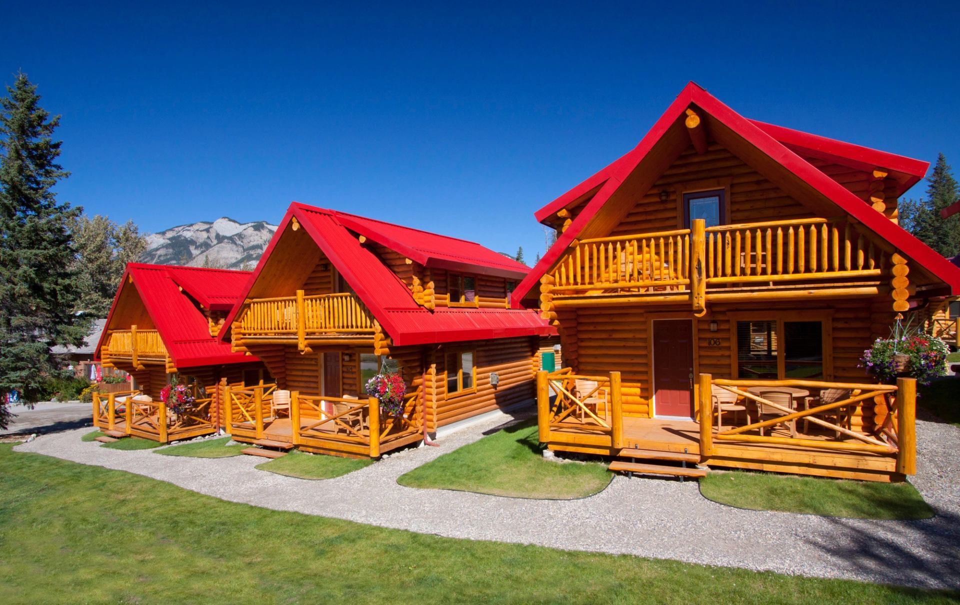 Three cabins with large decks and red rooftops in Jasper.