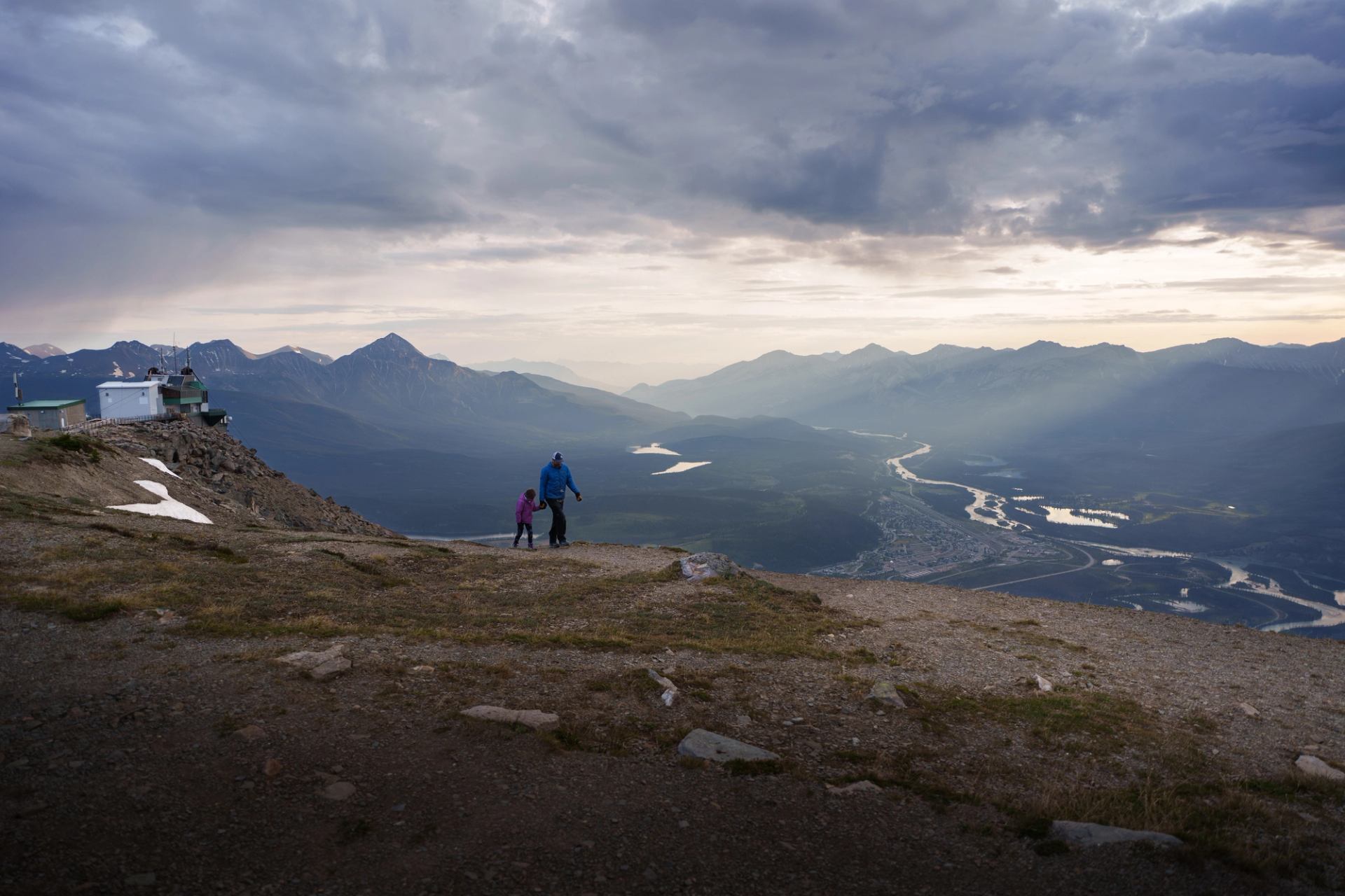 Man and his daughter walking the summit of Whistlers Mountain.