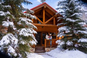 Couple enjoying a beverage in front of a Baker Creek Cabin