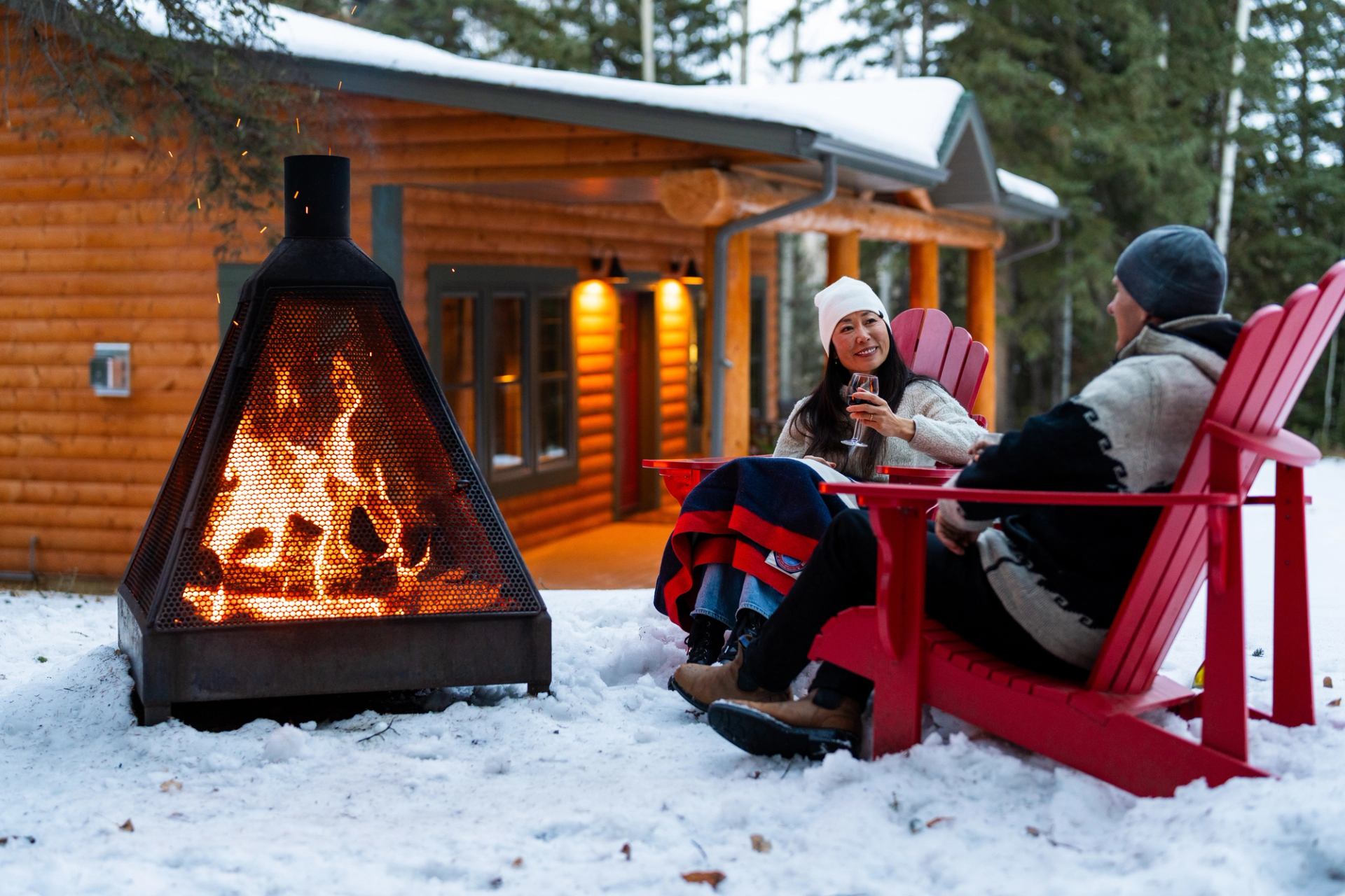 Couple enjoying a beverage at the outdoor fireplace at the Prairie Creek Inn
