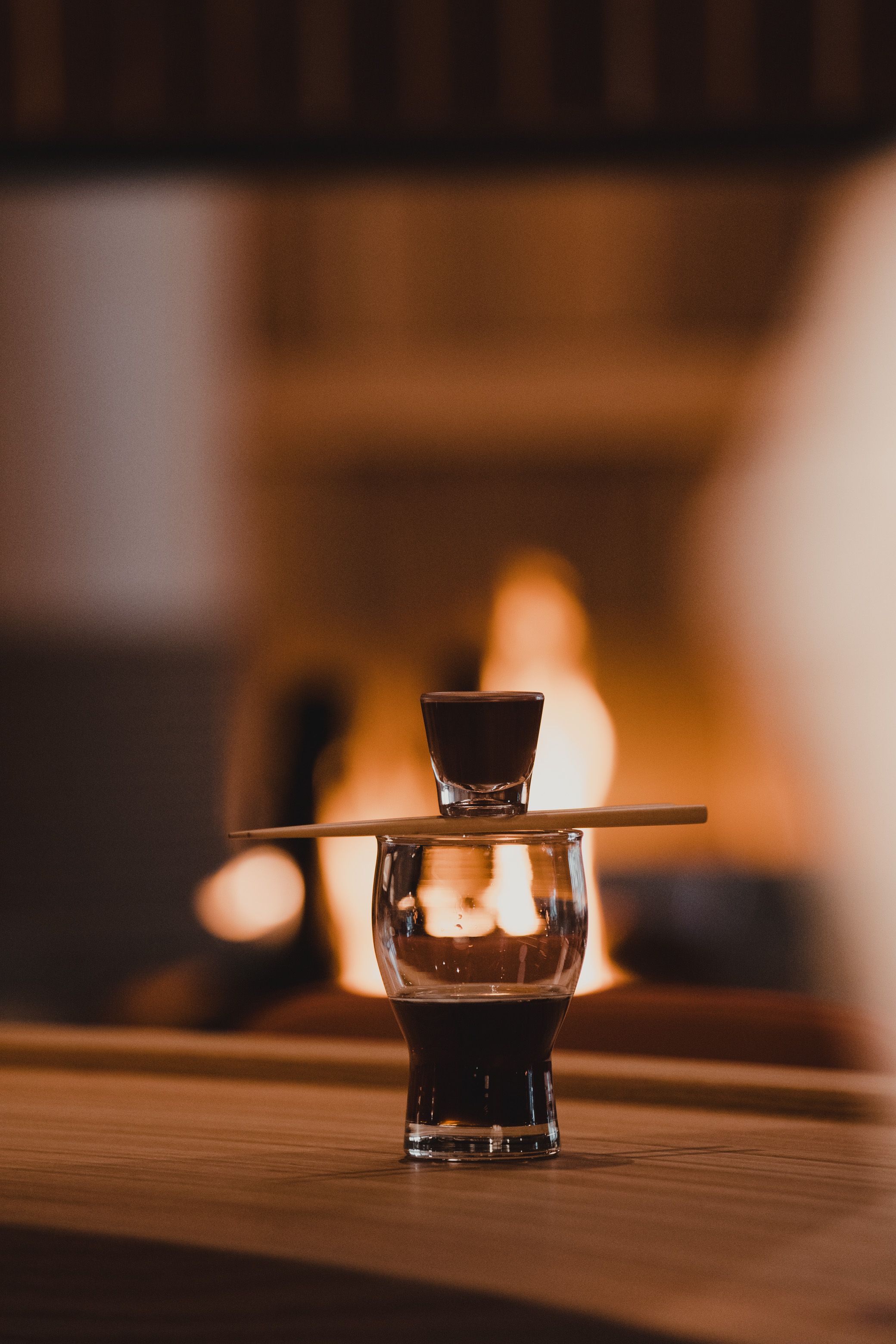 A shot oft chocolate sake balances on chopsticks over a glass of Mountain Joe, a coffee-vodka cocktail.