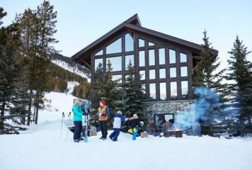 A family at the base of the hill, gear off after skiing Castle Mountain Resort