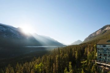 View from a hotel of sun-rays peaking over the mountain view onto the lake below.